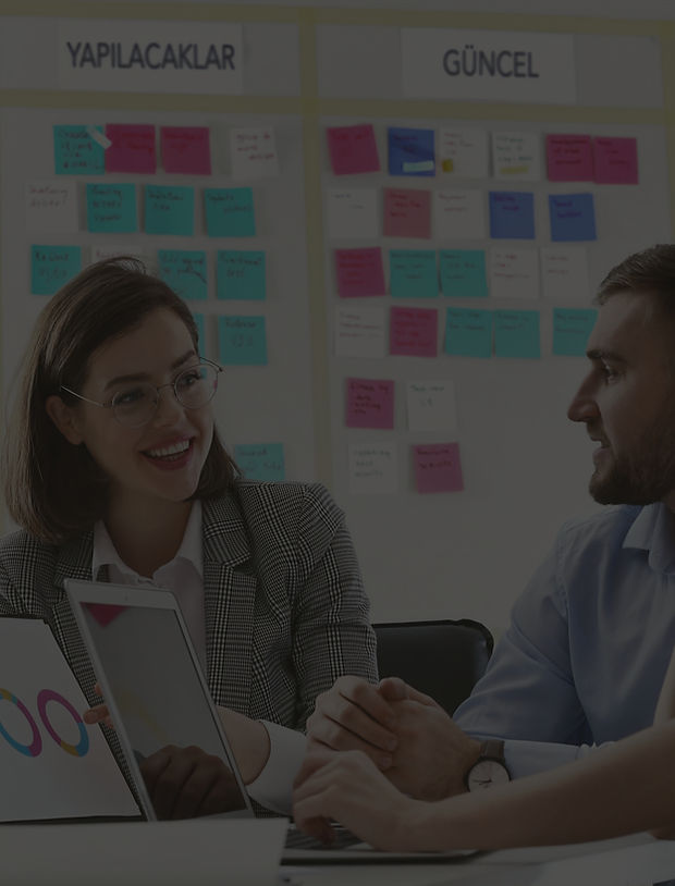 Dos profesionales conversan frente a un tablero de ideas